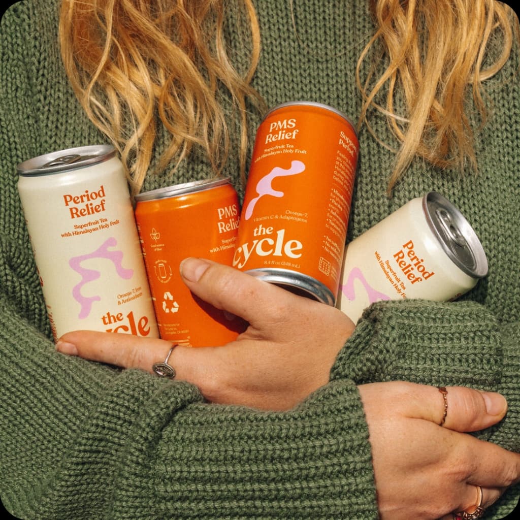 Hands holding The Cycle cans
